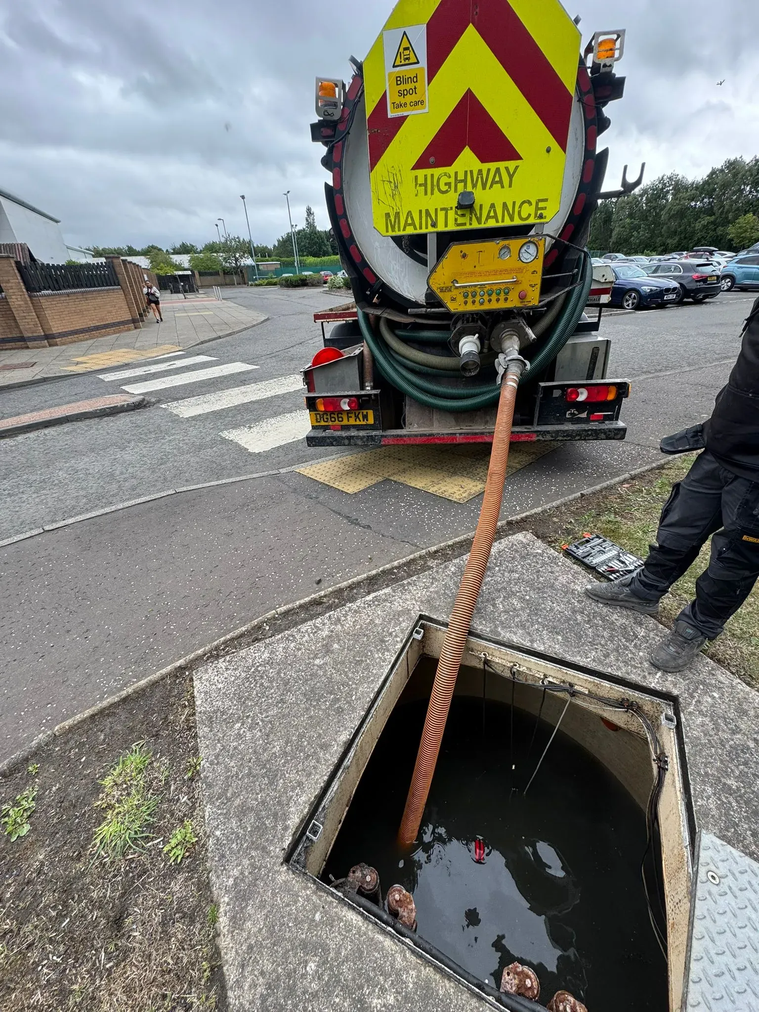 Vacuum tanker hose inserted into a drain or manhole